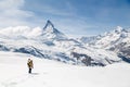 A man waving his hand standing on the snow in the background of Matterhorn. Royalty Free Stock Photo