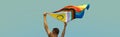 Man waving a progress pride flag outdoors, banner