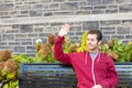 Man waving to somebody from a bench