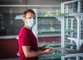 Man wear blue protective mask look at camera in empty shop store, COVID pandemic social panic. Stress question eyes