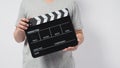 A man wear gray t-shirt and hand is holding black Clapper board or movie slate. it use in video production or cinema industry.It Royalty Free Stock Photo