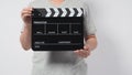 A man wear gray t-shirt and hand is holding black Clapper board or movie slate. it use in video production or cinema industry.It Royalty Free Stock Photo