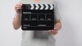 A man wear gray t-shirt and hand is holding black Clapper board or movie slate. it use in video production or cinema industry.It Royalty Free Stock Photo