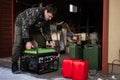 Man wear in military jacket with gasoline portable mobile backup standby generator