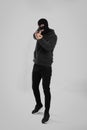 Man wearing black balaclava with gun on light grey background Royalty Free Stock Photo