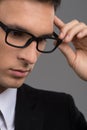 Man wearing black glasses on grey background. Royalty Free Stock Photo