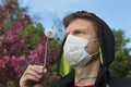 Man with a medical mask looking at dandelion