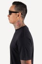 A man wearing black t shirt  on white background. Hipster man with tattoo wearing black t shirt and sunglasses, ready for Royalty Free Stock Photo