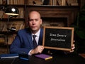 Man wearing blue business suit and showing chalkboard with written text Home Owners` Associations