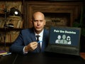 Man wearing blue business suit and showing laptop with written text Fair Use Doctrine . Blurred background. Horizontal mockup