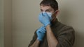 High quality close-up 4k slow motion video of a man wearing blue rubber protective medical gloves and blue medical face mask