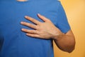 man wearing a blue shirt has chest pain caused by heart disease, heart attack, leaky heart disease, coronary artery disease during Royalty Free Stock Photo