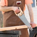 Man Wearing Brown Apron and Sawing Wood Royalty Free Stock Photo