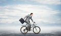 Man wearing business suit riding bicycle outdoor. Royalty Free Stock Photo