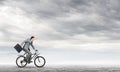 Man wearing business suit riding bicycle outdoor. Royalty Free Stock Photo