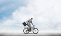 Man wearing business suit riding bicycle outdoor. Royalty Free Stock Photo