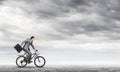 Man wearing business suit riding bicycle outdoor. Royalty Free Stock Photo