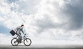 Man wearing business suit riding bicycle outdoor. Royalty Free Stock Photo