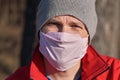 Man wearing cotton home made virus nose mouth face mask, closeup portrait. Coronavirus covid-19 outbreak prevention concept