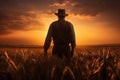 A man wearing a cowboy hat stands confidently in a beautiful open field, Silhouette of a farmer amidst a wheat field, gazing at