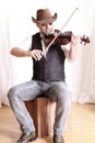 Man wearing cowboy leather hat playing fiddle