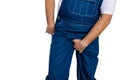 Man wearing denim dungarees scratching his crotch