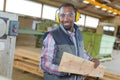 Man wearing earmuffs holding plank wood Royalty Free Stock Photo