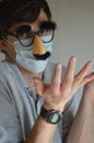 Man wearing face mask and Groucho glasses