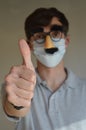 Man wearing face mask and Groucho glasses