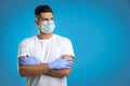 Man wearing protective face mask and medical gloves on blue background. Space for text Royalty Free Stock Photo
