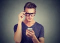 Man wearing glasses having trouble seeing cell phone has vision problems. Royalty Free Stock Photo