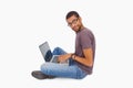 Man wearing glasses sitting on floor using laptop and looking at Royalty Free Stock Photo