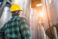 Man Wearing Hard Hat Looking Up At Large Industrial Tanks Royalty Free Stock Photo