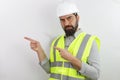 Man wearing hardhat and reflecting jacket thinking worried, looking at the camera pointing with two hands and fingers t