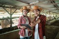 man wearing a hat with finger pointing pose as the ranch owner uses a digital tablet