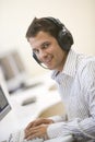 Man wearing headphones in computer room typing Royalty Free Stock Photo