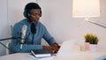 Man wearing headphones doing an online meeting using a laptop and microphone. Concept of online meetings or podcasts Royalty Free Stock Photo