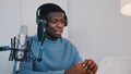 Man wearing headphones recording a video podcast using a laptop and microphone Royalty Free Stock Photo