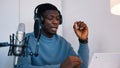 Man wearing headphones recording a video podcast using a laptop and microphone Royalty Free Stock Photo