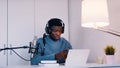 Man wearing headphones taking an online using a laptop and microphone Royalty Free Stock Photo