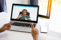 A man wearing headphones is using a laptop to communicate via video conferencing. Conversation during the coronavirus or COVID 19 Royalty Free Stock Photo