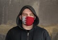 Man Wearing a hood and a Bahrain flag Mask to Protect him virus