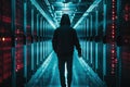 A man wearing a hooded jacket walks through a long hallway, An ominous shadow lurking over a secure network, symbolizing latent Royalty Free Stock Photo