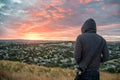 Man wearing hoody watching sunrise over Auckland city Royalty Free Stock Photo