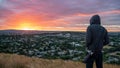 Man wearing hoody watching sunrise over Auckland city Royalty Free Stock Photo