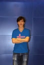 Man wearing Iceland flag pattern shirt and cross one`s arm on the blue wall background