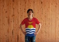 Man wearing Kiribati flag color shirt and standing with akimbo on the wooden wall background Royalty Free Stock Photo