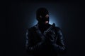 Man wearing knitted balaclava with gun on black Royalty Free Stock Photo