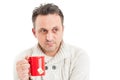 Man wearing knitted pullover holding a mug of hot tea