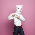 Man wearing lama mask making heart with hands on bright pink background